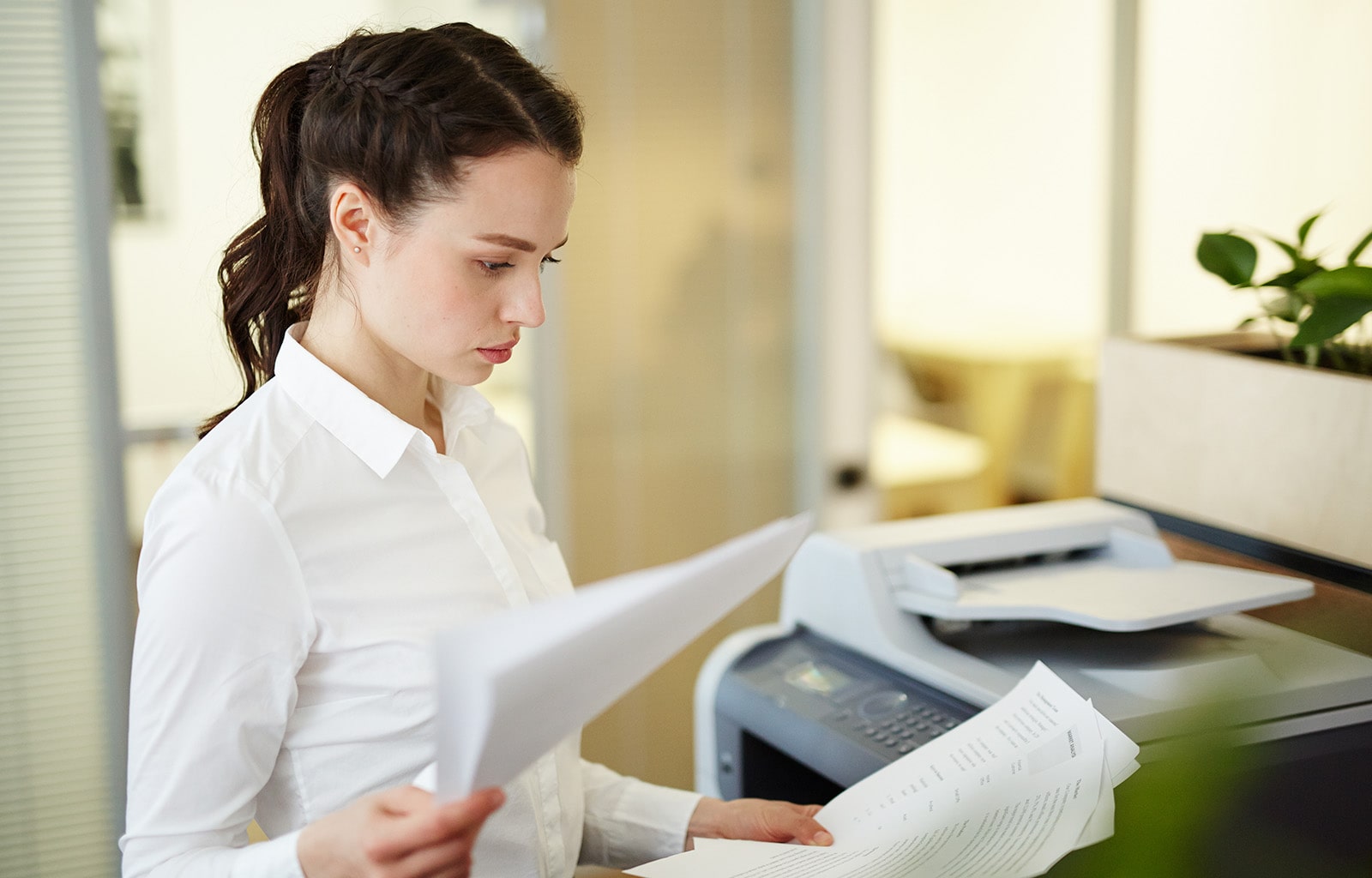 Woman in white holding sheets of paper